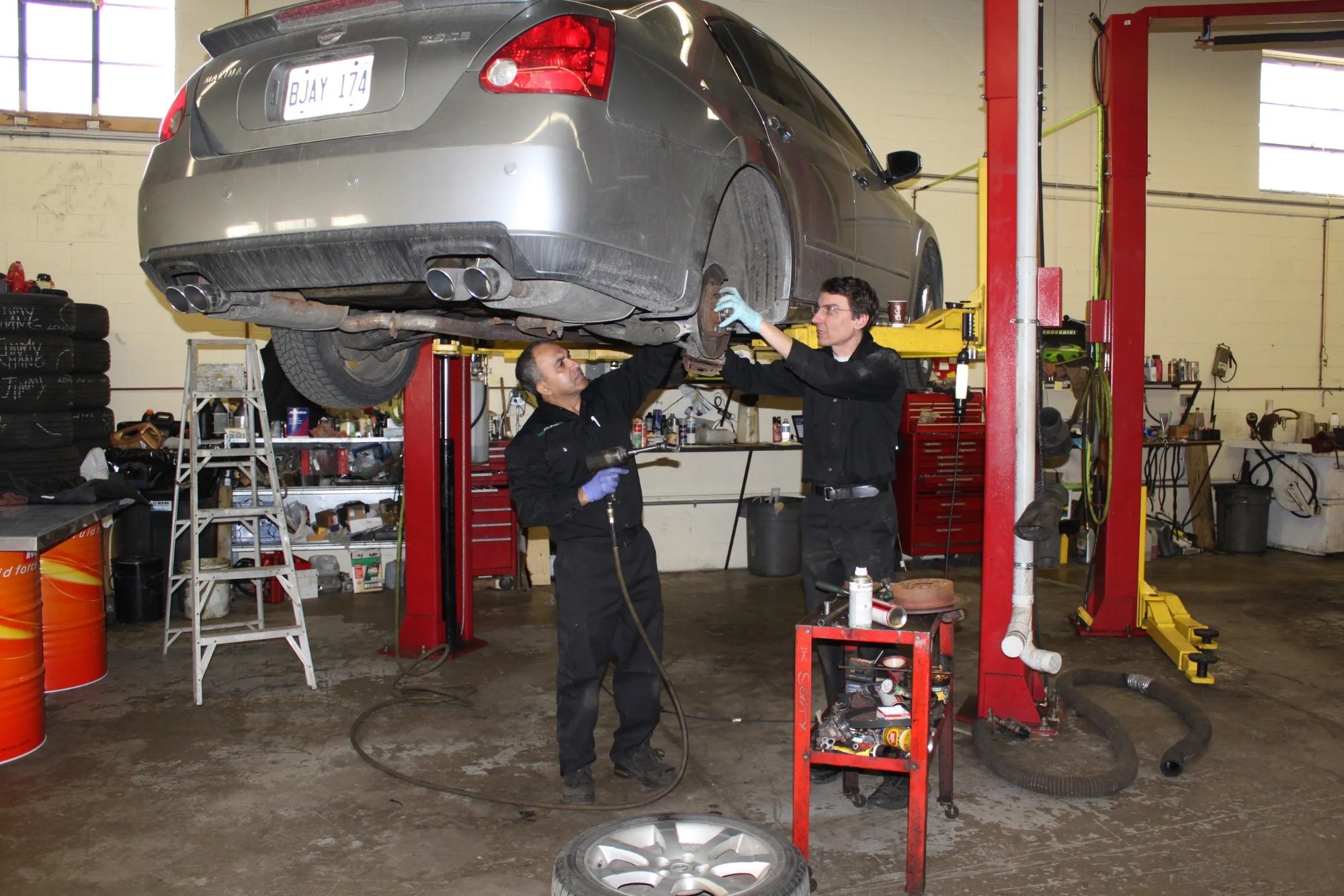 Expert technicians working on lifted vehicle